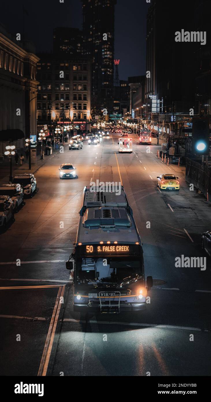 Autobus che guida lungo Vancouver Street di notte Foto Stock