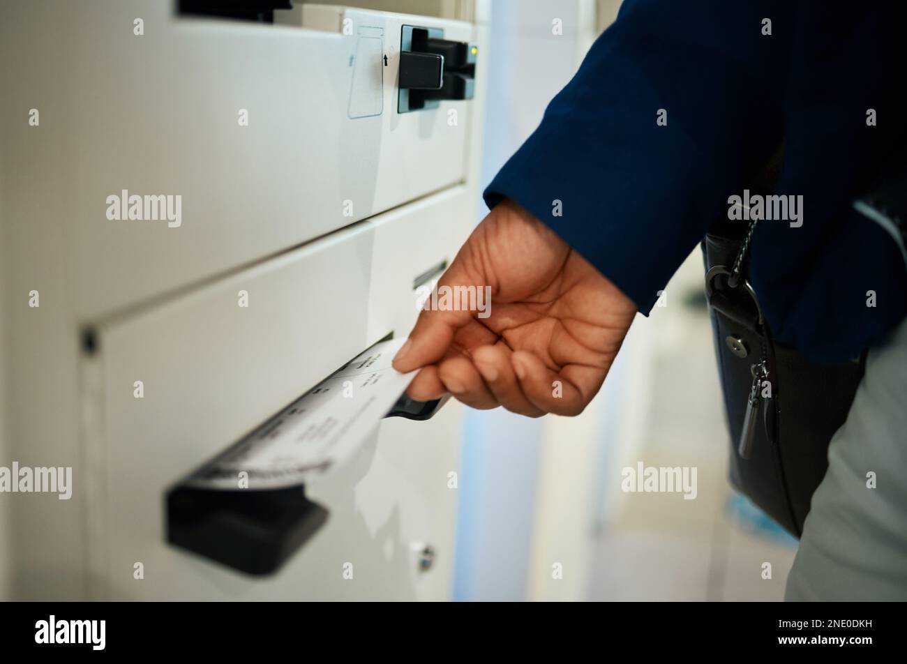 Mani, biglietto e aeroporto presso un distributore self-service per il check-in, volo o carta d'imbarco per viaggiare. Mano del viaggiatore che prende i biglietti dell'aereo per viaggiare Foto Stock