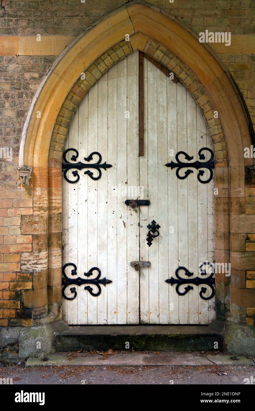 La vecchia porta di una cappella con cerniere decorative in metallo Foto Stock