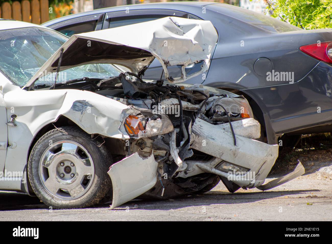 Due vetture su strada dopo una collisione. Avventura su strada e paraurti, cofano, fari e parafango rotti su un'auto bianca Foto Stock