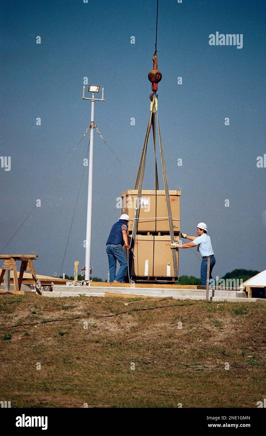 Workmen shift a huge crate containing debris from the Space Shuttle Challenger as it is lowered into an unused Minuteman missile silo at the Kennedy Space Center on Thursday, Jan. 8, 1987. The silos are 78 feet deep and will be filled with the debris, a process that is expected to take over two months to complete. Challenger exploded shortly after it was launch on January 28th last year, killing all seven crewmen aboard. (AP Photo/Jim Neihouse) Foto Stock