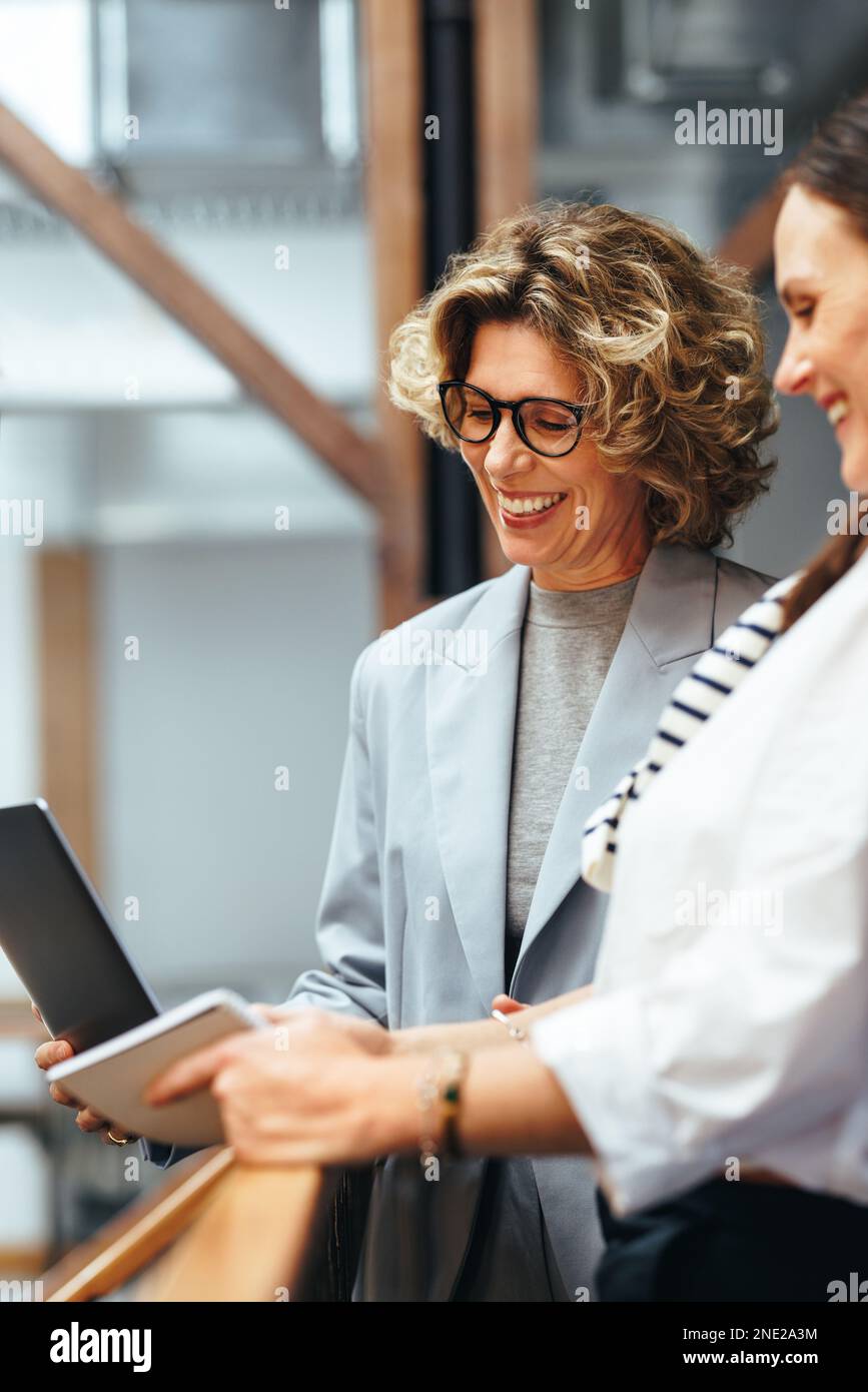 Imprenditrici che fanno una videochiamata in un ufficio. Donne in viaggio d'affari felici che hanno una riunione virtuale su un notebook. Due donne d'affari che partecipano ad un Foto Stock