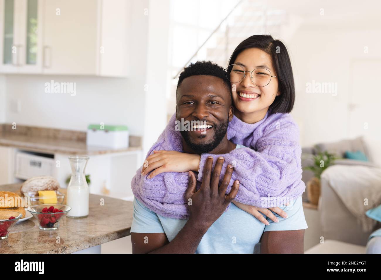 Ritratto di felice coppia varia abbracciando in cucina. Trascorrere il tempo di qualità a casa, la vita domestica e il concetto di stile di vita. Foto Stock