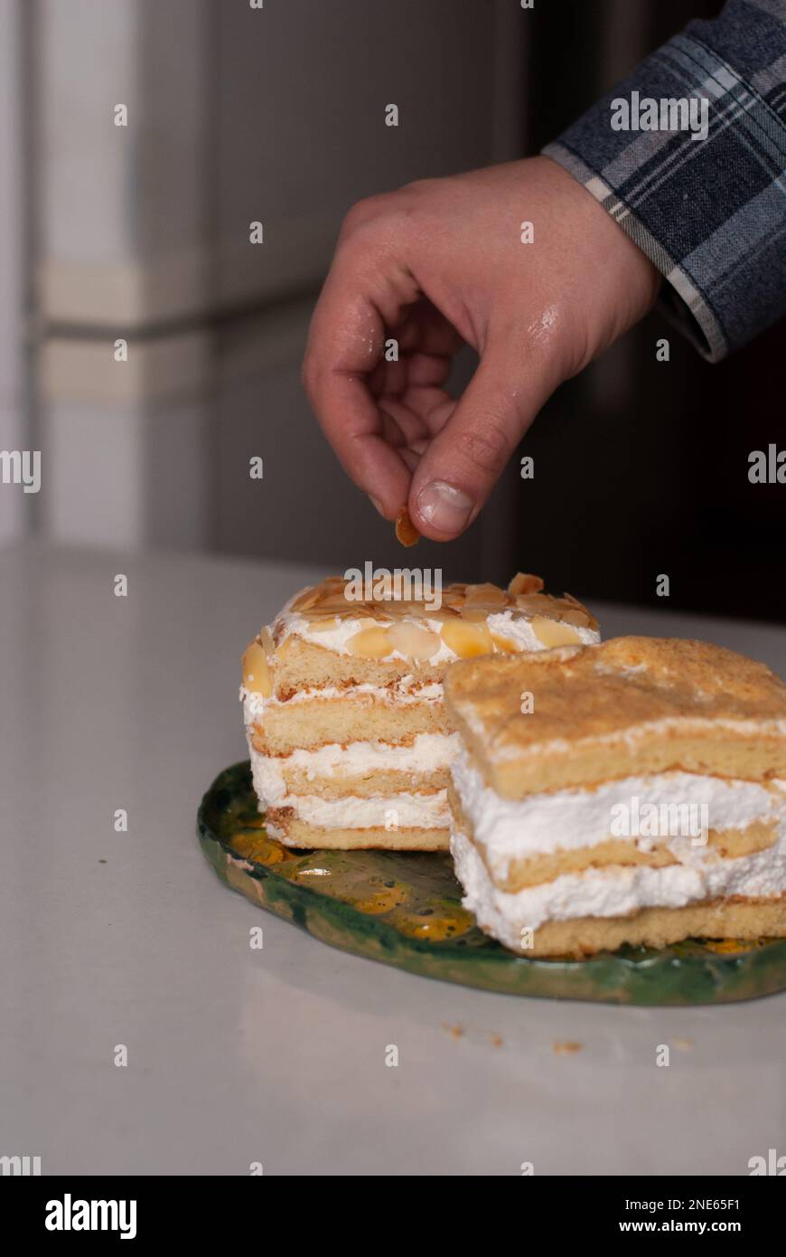 L'uomo mette una mandorla su una torta cremosa Foto Stock