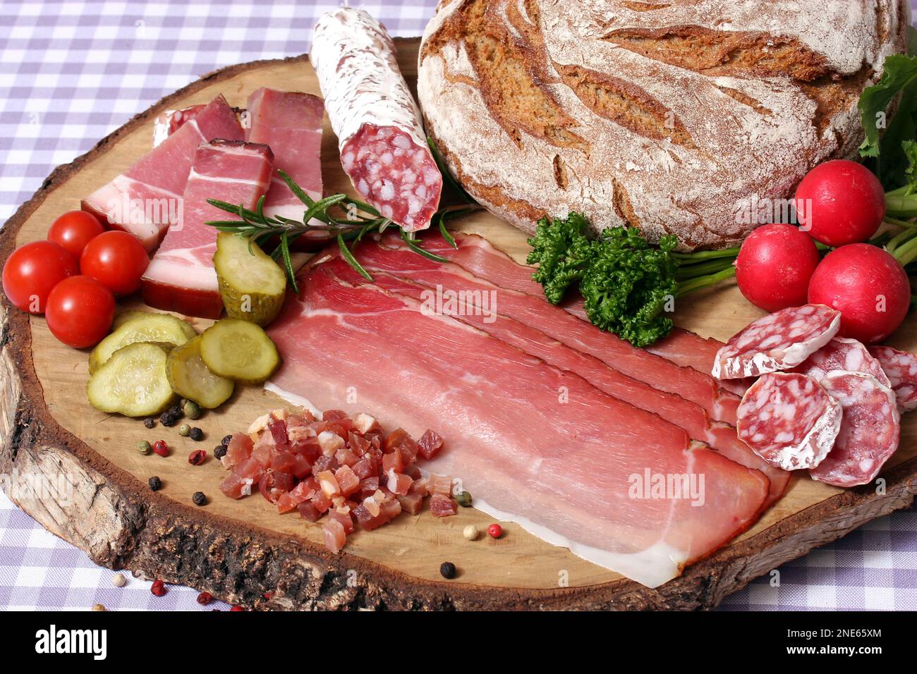 snack con pane, salame francese, prosciutto essiccato all'aria, pancetta, ravanelli, cetriolo e pomodori Foto Stock