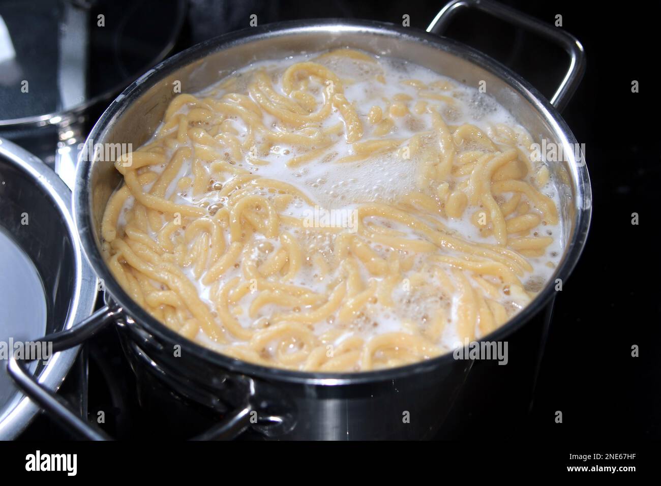 cuocere le uova di spaetzle fresche in una pentola Foto Stock