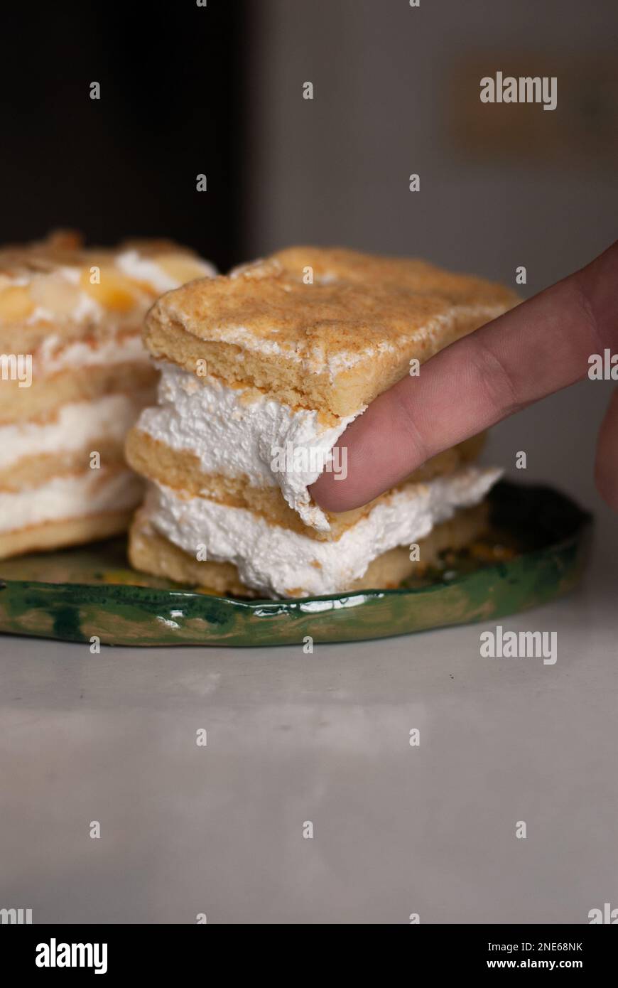 Crema di torta su un dito di un uomo Foto Stock