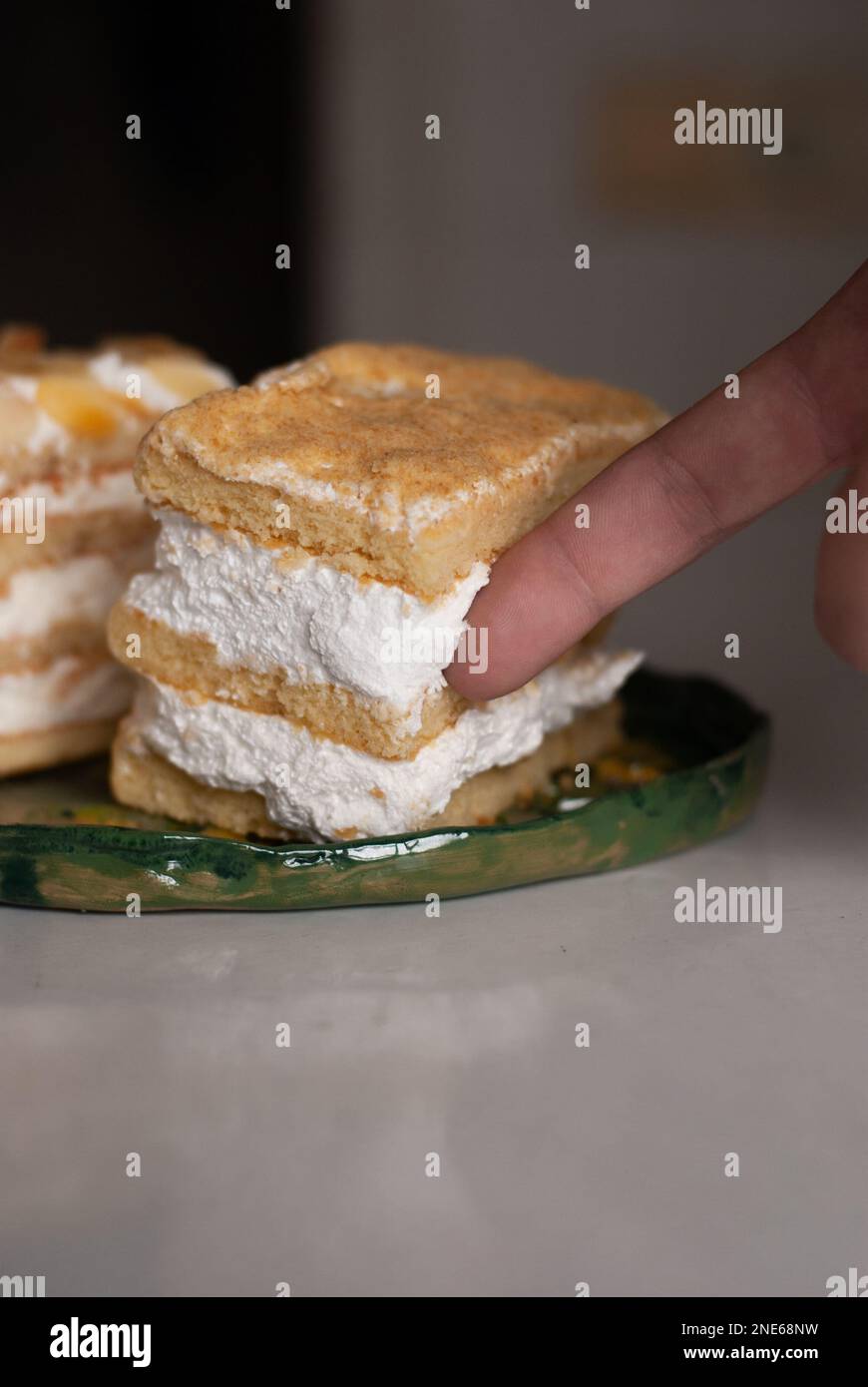 Crema di torta su un dito di un uomo Foto Stock