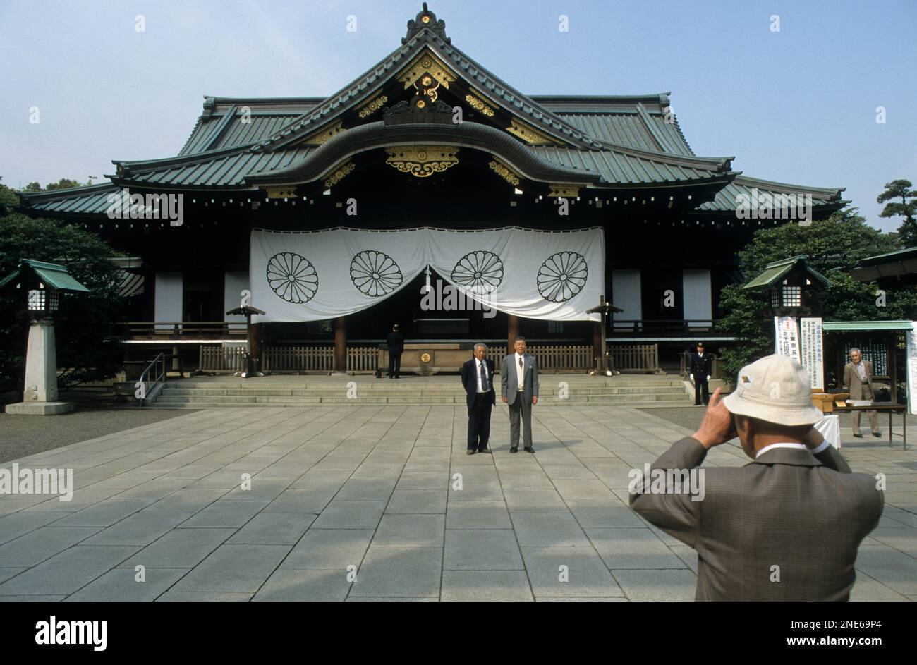 Giappone, Tokyo, Chiyoda, Yasukuni Jinja santuario, il santuario dedicato alle vite perse in azione. Un turista giapponese ha la sua foto scattata di fronte alla shr. Foto Stock
