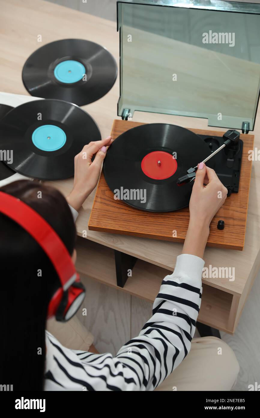 Donna che ascolta musica con giradischi a casa, vista dall'alto Foto Stock