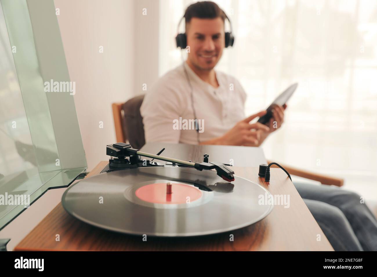 Uomo che ascolta musica a casa, concentrati sul giradischi con disco in vinile Foto Stock