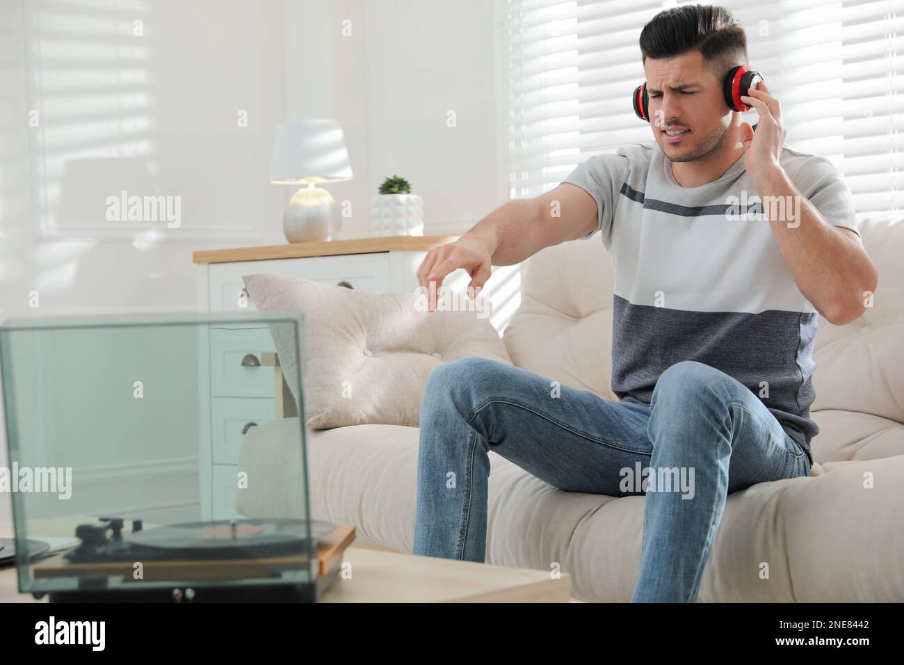 Uomo emozionale che ascolta la musica con il giradischi a casa Foto Stock