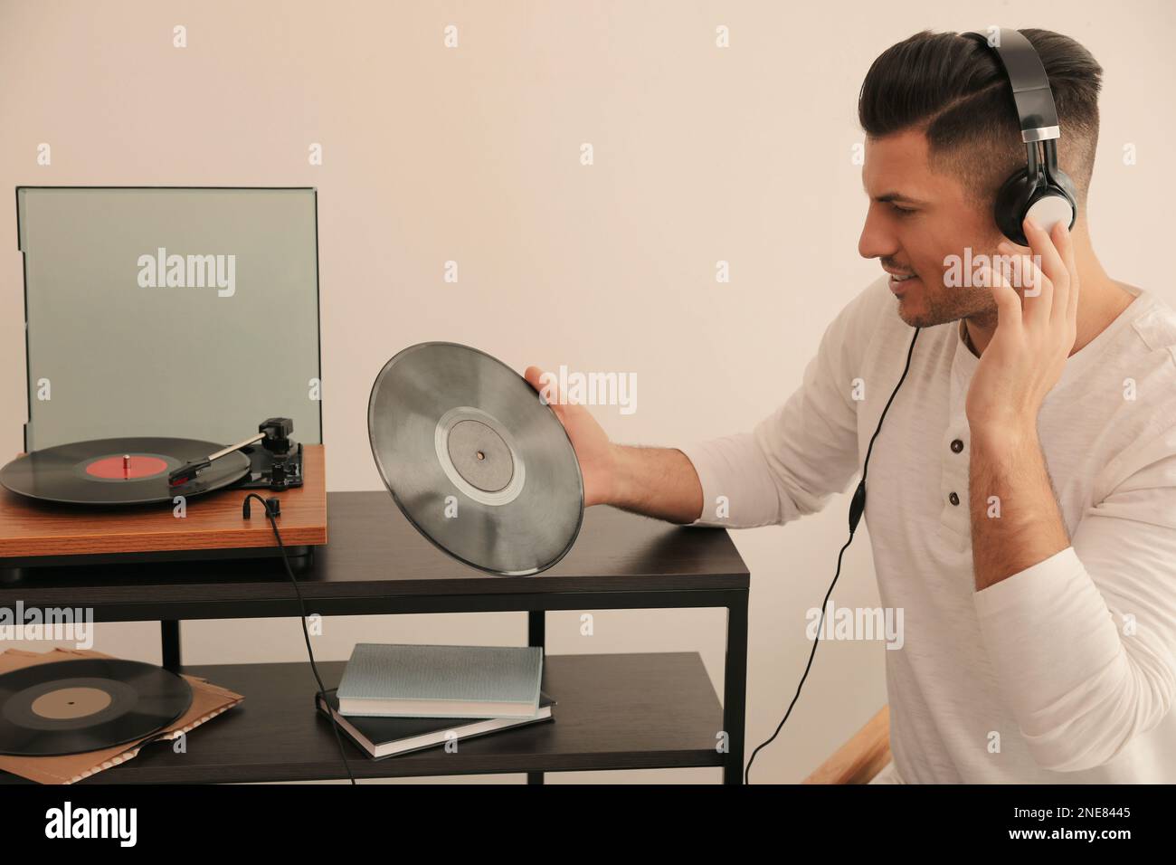 Un uomo felice che ascolta la musica con il giradischi a casa Foto Stock