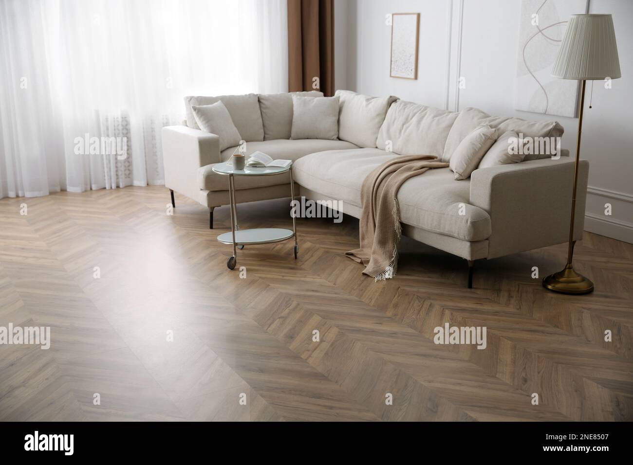 Moderno soggiorno con pavimenti in parquet e mobili eleganti Foto Stock