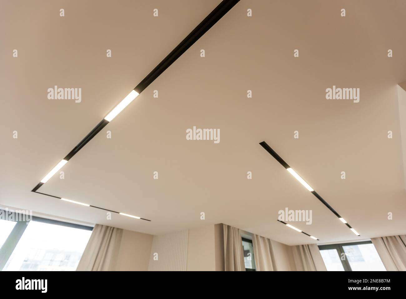 Illuminazione e illuminazione a striscia a LED. Chiamata anche luce a nastro o nastro a LED sospeso sul soffitto in cartongesso nel soggiorno vuoto includono la luce verso il basso Foto Stock