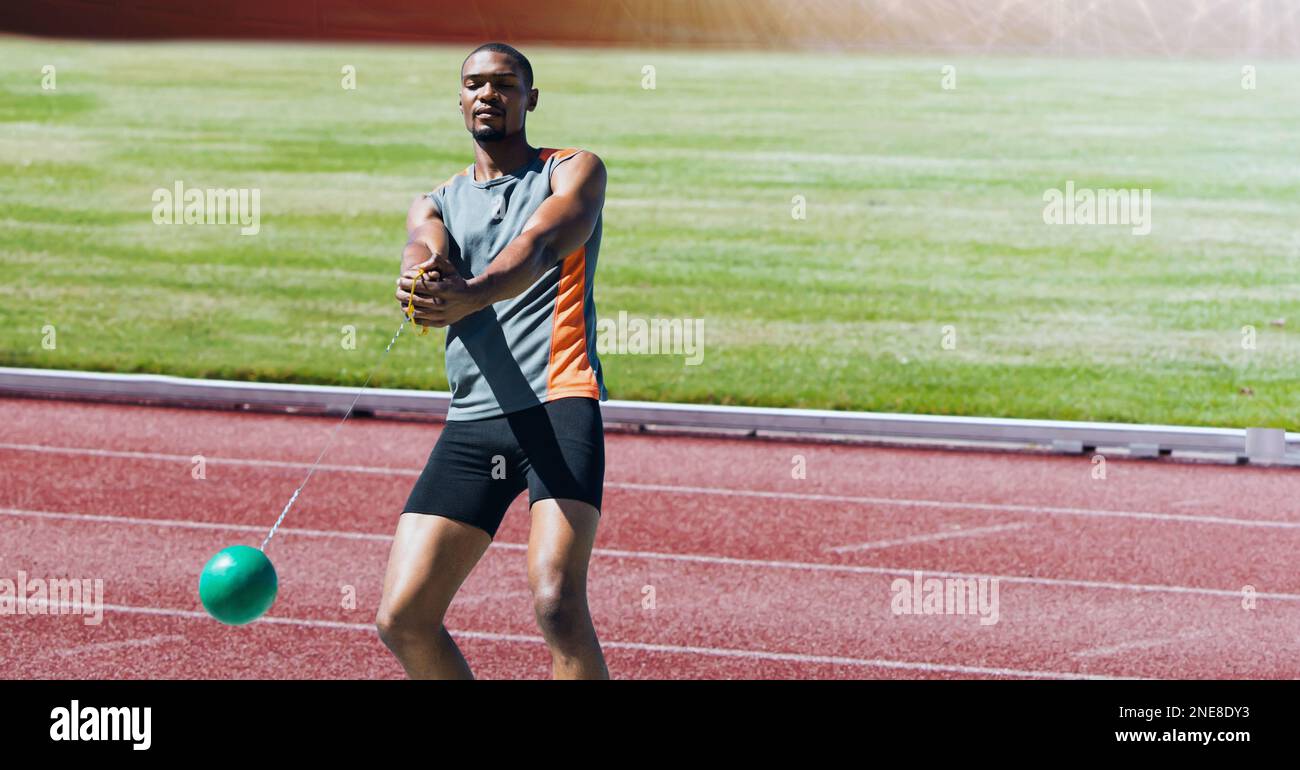 Atleta afro-americano maschio martello lancio contro il campo sportivo in background Foto Stock