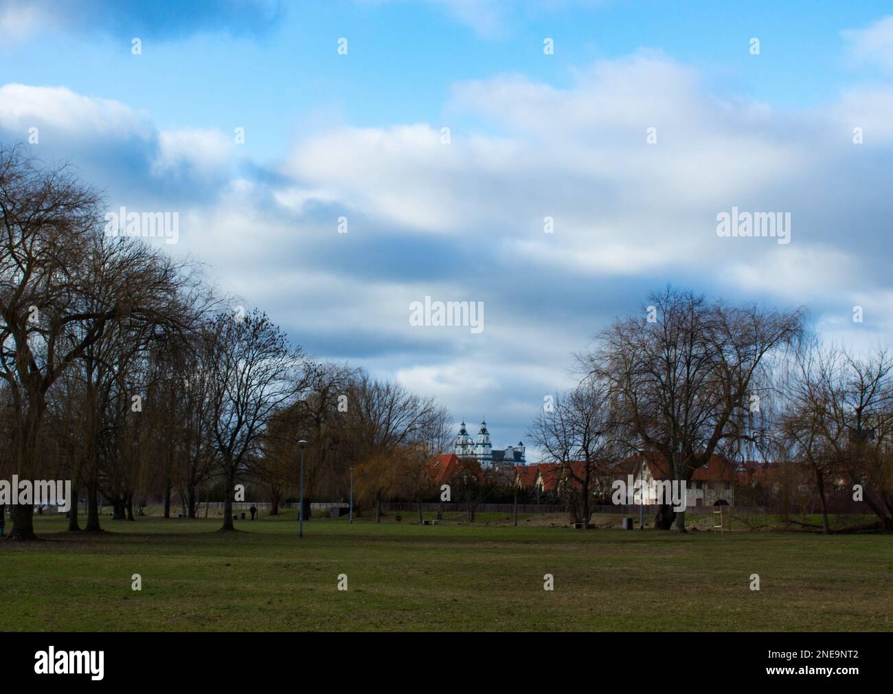 Mattina vista dal parco alla tenuta di case e la chiesa 17.02.2023 Bialystok Polonia. Belle nuvole nel cielo e una vista sul parco della città. Foto Stock