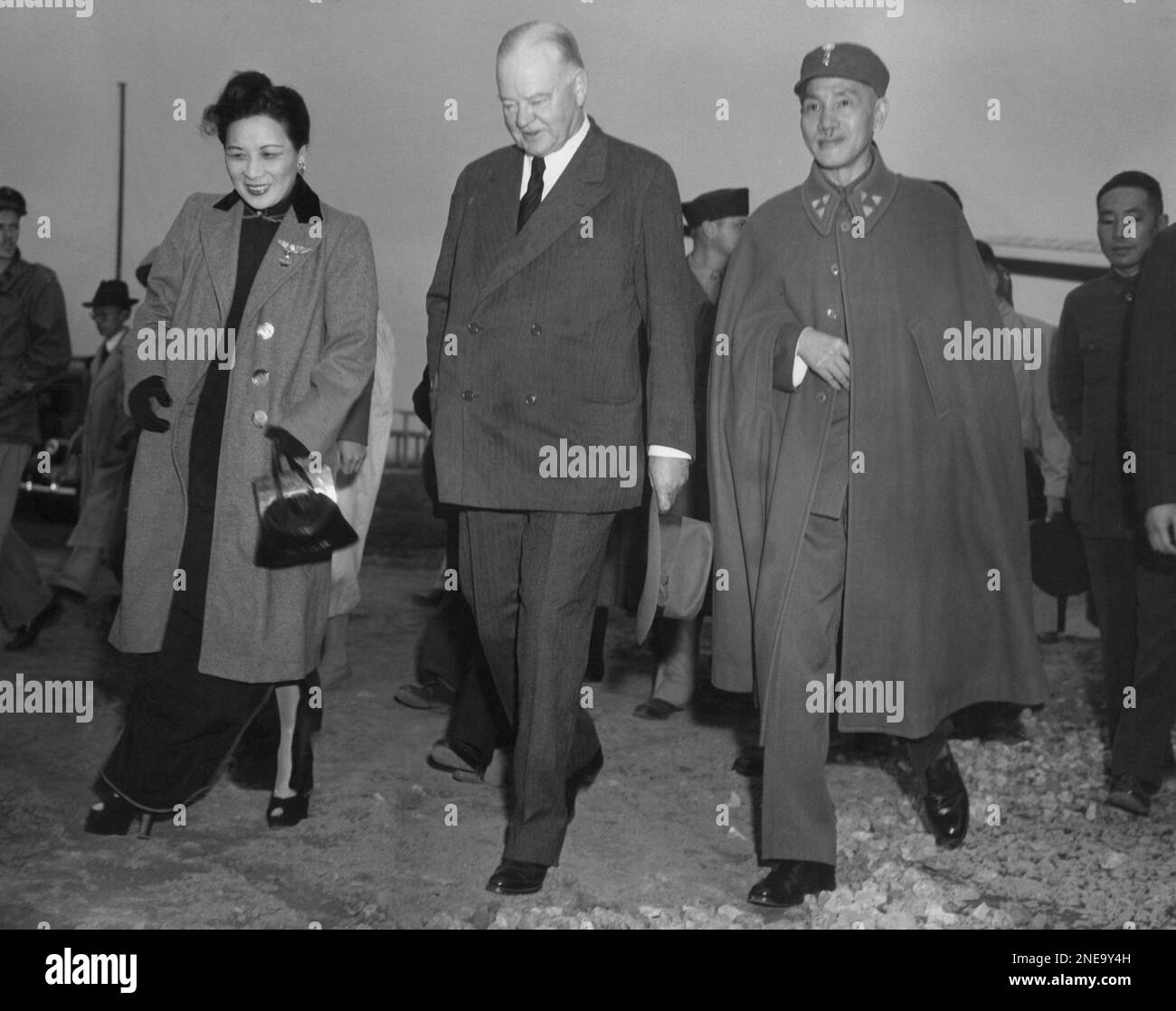 Herbert Hoover, center, walks to his plane with Generalissimo and Madame Chiang Kaishek in