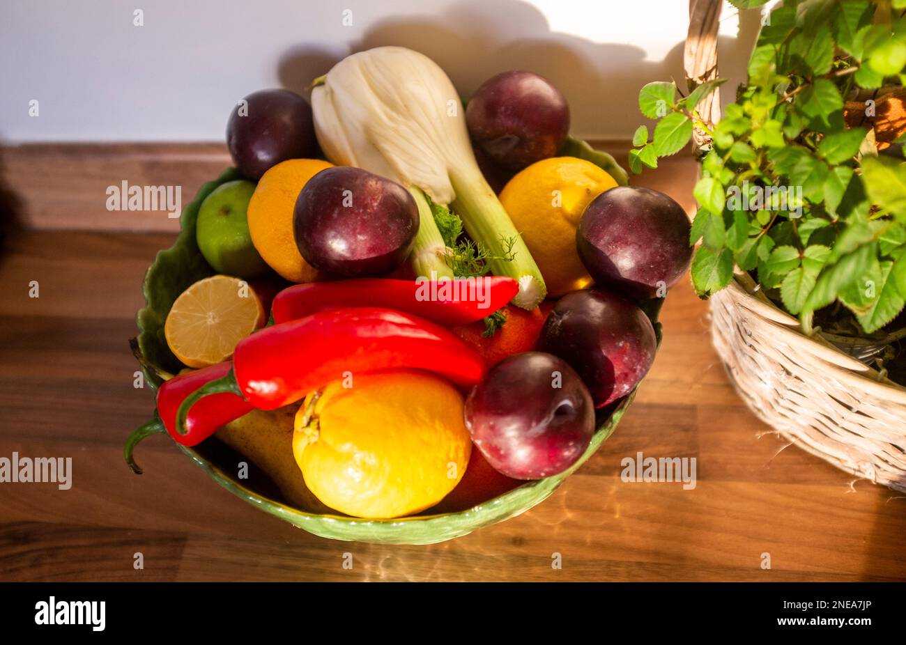 Ciotola di frutta contenente finocchio , prugne , peperoncini rossi e limoni Foto Stock