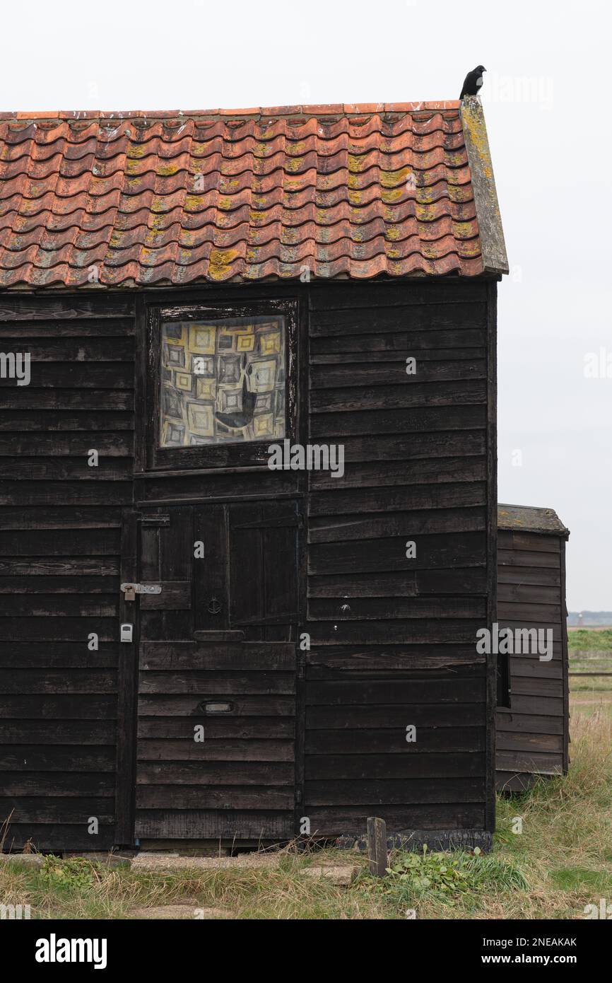 Capanne nere a Walberswick, Suffolk. Grigio, giorno di Moody. Foto Stock