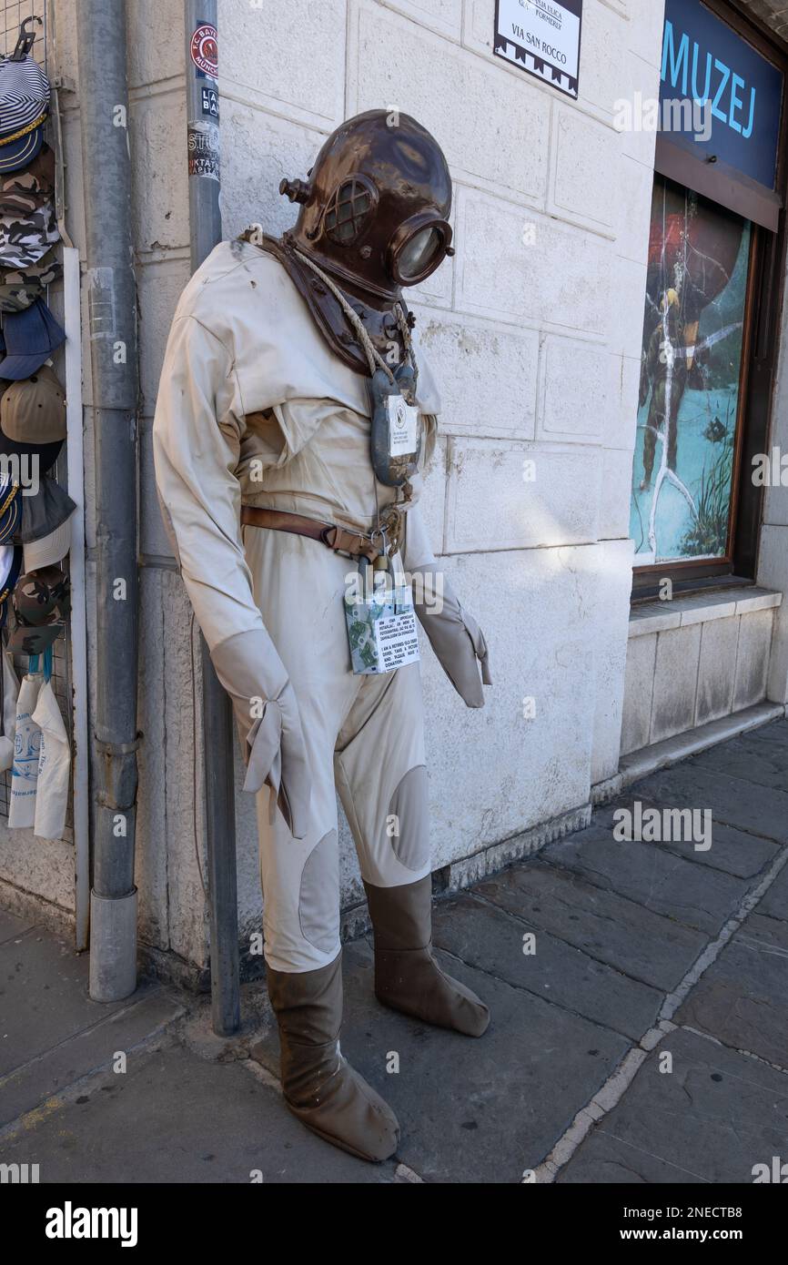 Vecchia tuta subacquea con elmetto (cappello di rame) e scatola per donazioni sul marciapiede della città costiera di Pirano in Slovenia. Foto Stock
