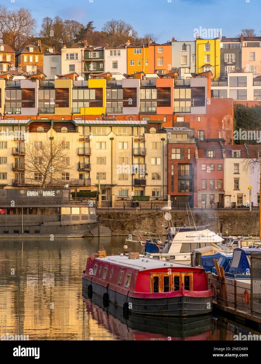 Barche ormeggiate a Bristol Marina con case colorate dipinte e appartamenti nella zona di Cliftonwood in lontananza. Bristol. REGNO UNITO Foto Stock