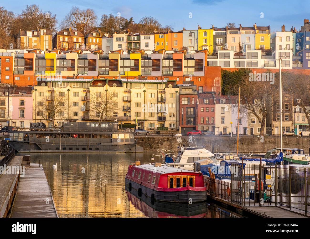 Barche ormeggiate a Bristol Marina con case colorate dipinte e appartamenti nella zona di Cliftonwood in lontananza. Bristol. REGNO UNITO Foto Stock