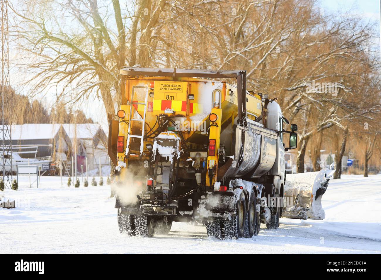 Autocarro dotato di spazzaneve e spargitore di sale stradale in movimento dopo le nevicate invernali nel sud della Finlandia. Salo, Finlandia. Febbraio 11, 2023. Foto Stock