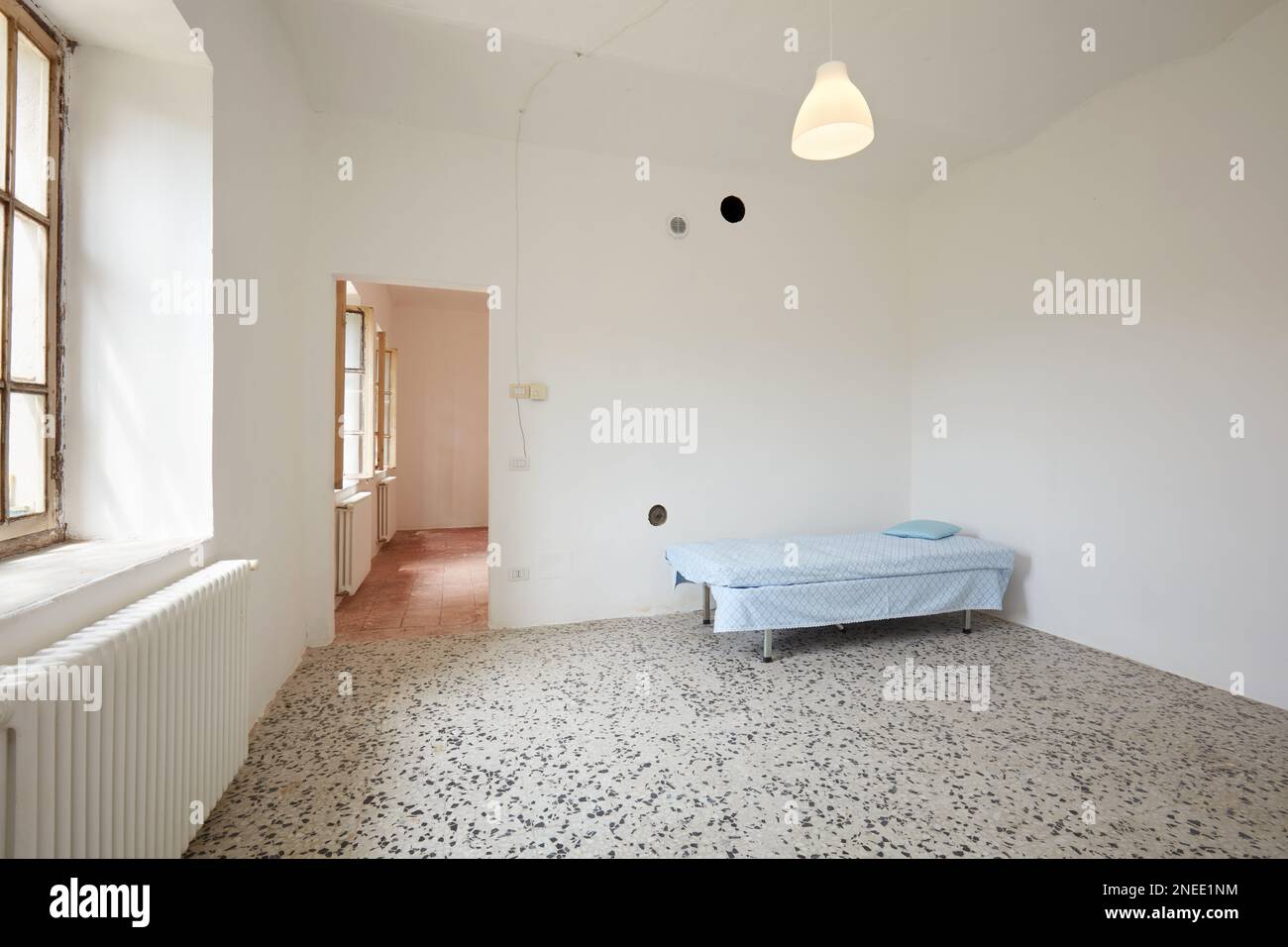 Camera da letto con letto sigle in vecchia casa di campagna con pareti bianche Foto Stock