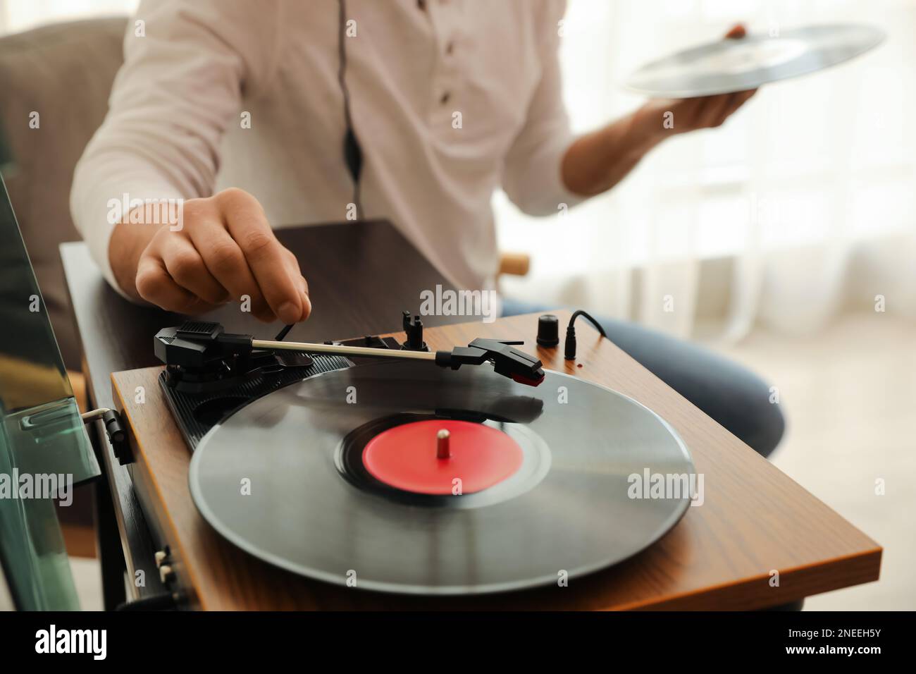 Uomo che usa il giradischi a casa, vista in primo piano Foto Stock