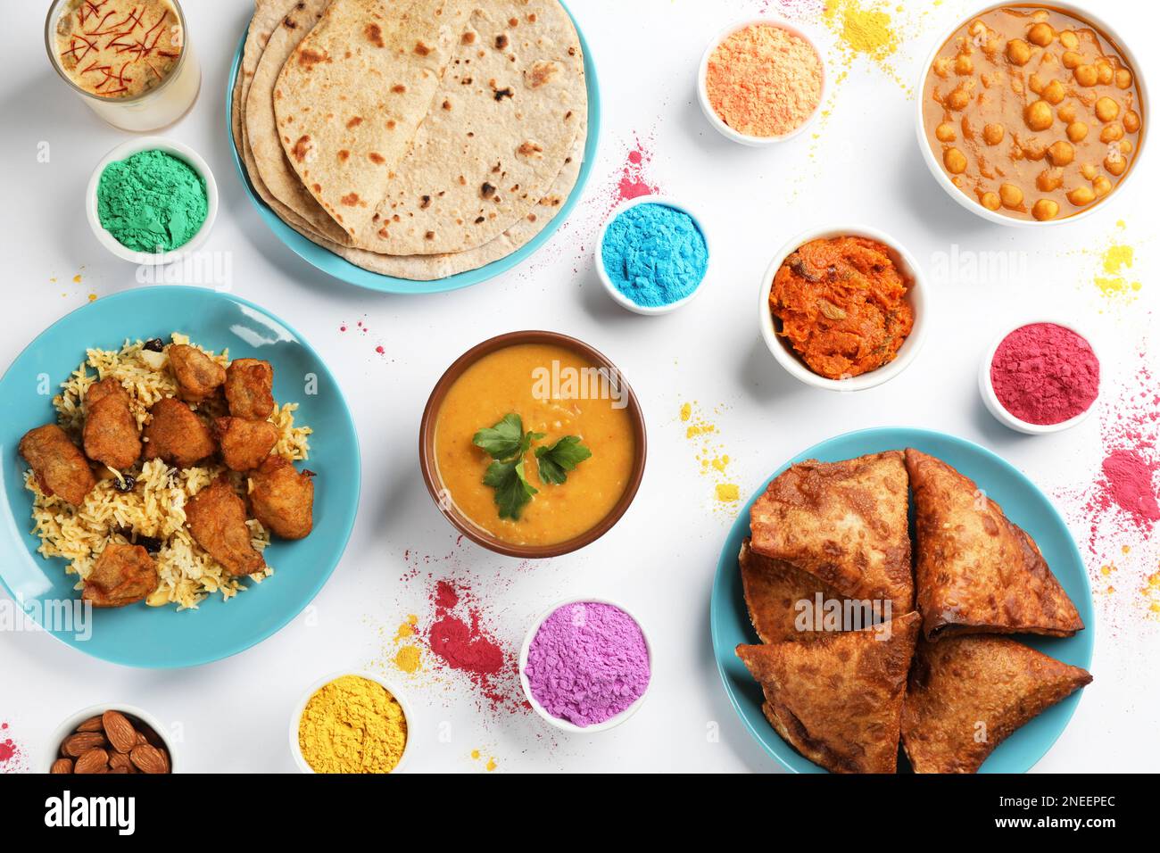 Cibo tradizionale indiano e coloranti in polvere su sfondo chiaro, piatto. Festa di Holi Foto Stock