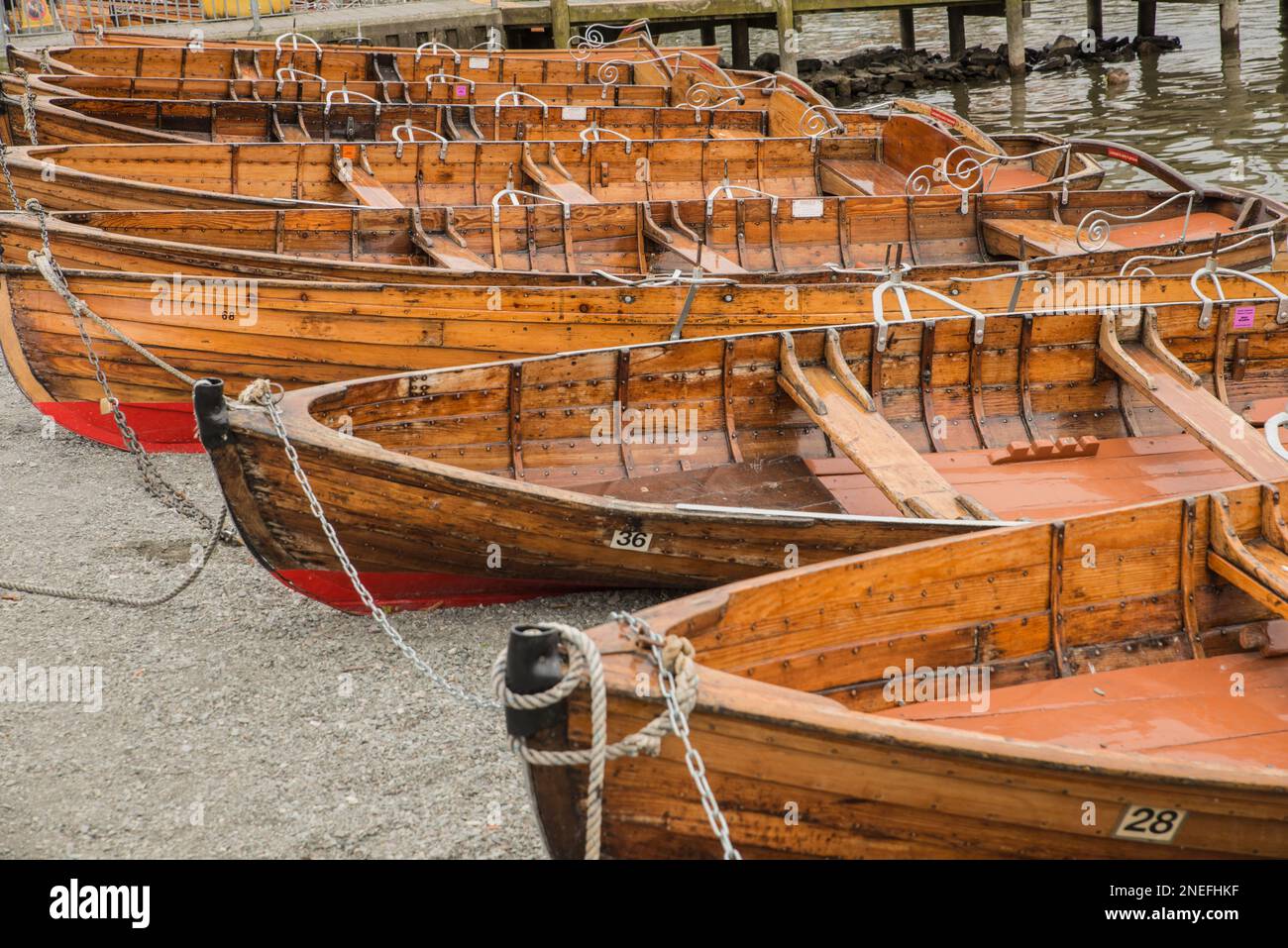 Vecchie barche a remi tradizionali in legno trasportavano sulla riva del lago Windermere nel Lake District National Park, Cumbria, Inghilterra Foto Stock