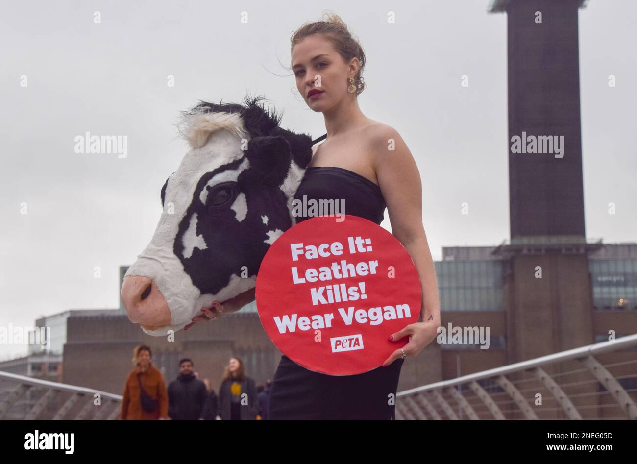 Londra, Regno Unito. 16th Feb, 2023. PETA (persone per il trattamento etico degli animali) ha messo in scena una passerella sul Millennium Bridge alla vigilia della London Fashion Week con un modello che indossa un vestito con la testa di una vacca sintetica e un cartello con la scritta "pelle uccide, indossa vegan". La stunt mira a ispirare le persone a scopare la pelle animale e fa riferimento alle "teste animali" di Schiaparelli, che di recente hanno causato molte polemiche alla settimana della moda di Parigi. Credit: SOPA Images Limited/Alamy Live News Foto Stock