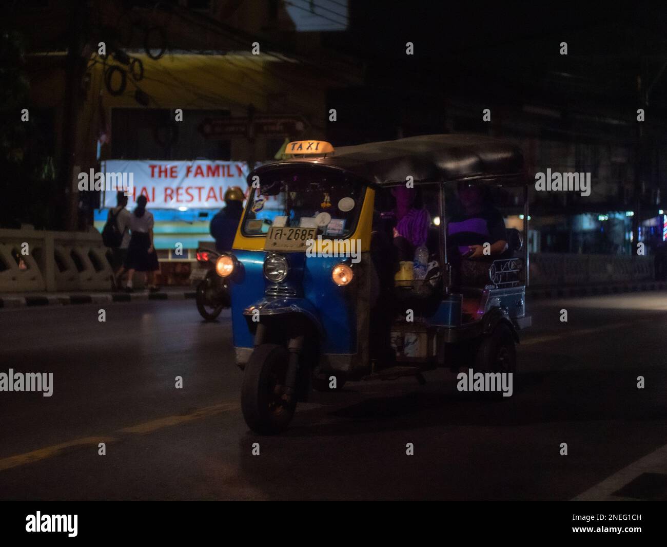 Un risciò che attraversa Bangkok di notte. Foto Stock