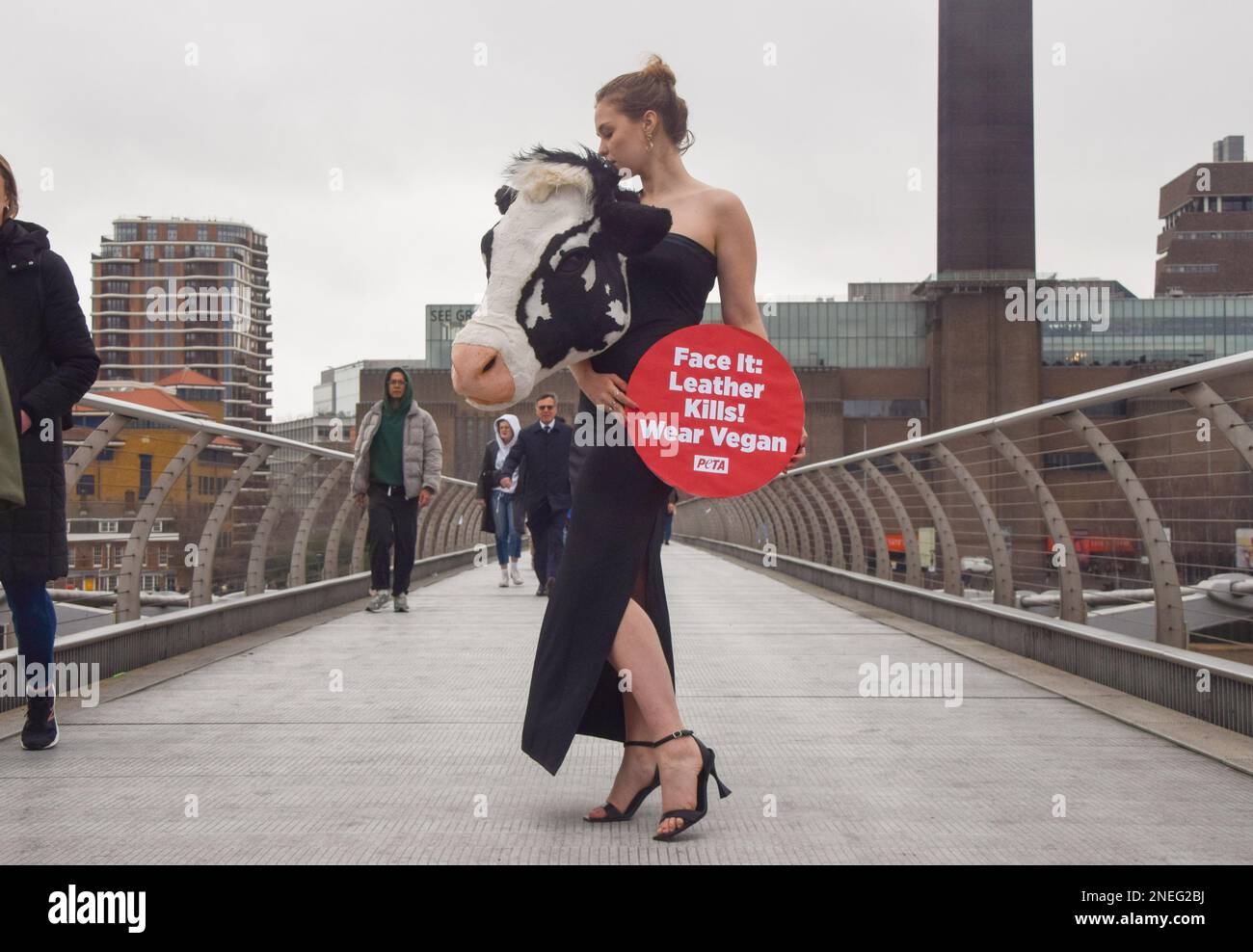 Londra, Regno Unito. 16th Feb, 2023. PETA (persone per il trattamento etico degli animali) ha messo in scena una passerella sul Millennium Bridge alla vigilia della London Fashion Week con un modello che indossa un vestito con la testa di una vacca sintetica e un cartello con la scritta "pelle uccide, indossa vegan". La stunt mira a ispirare le persone a scopare la pelle animale e fa riferimento alle "teste animali" di Schiaparelli, che di recente hanno causato molte polemiche alla settimana della moda di Parigi. (Foto di Vuk Valcic/SOPA Images/Sipa USA) Credit: Sipa USA/Alamy Live News Foto Stock