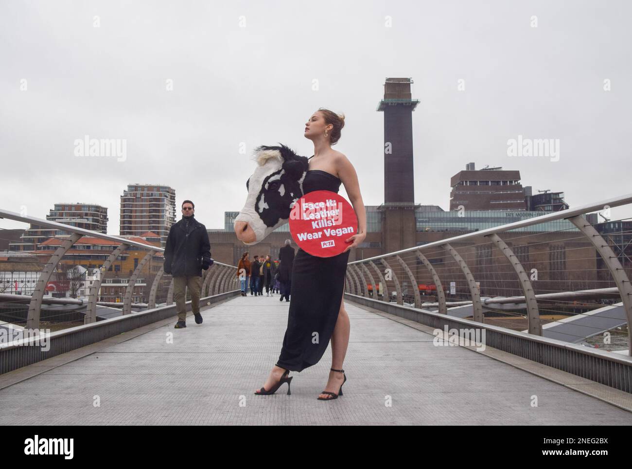 Londra, Regno Unito. 16th Feb, 2023. PETA (persone per il trattamento etico degli animali) ha messo in scena una passerella sul Millennium Bridge alla vigilia della London Fashion Week con un modello che indossa un vestito con la testa di una vacca sintetica e un cartello con la scritta "pelle uccide, indossa vegan". La stunt mira a ispirare le persone a scopare la pelle animale e fa riferimento alle "teste animali" di Schiaparelli, che di recente hanno causato molte polemiche alla settimana della moda di Parigi. (Foto di Vuk Valcic/SOPA Images/Sipa USA) Credit: Sipa USA/Alamy Live News Foto Stock