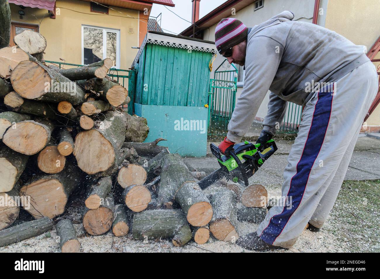 Lviv, Ucraina 16 febbraio 2023. Uomo che taglia legno con motosega. Le persone raccolgono legna da ardere per sopravvivere durante l'inverno durante l'attacco della Russia alle infrastrutture energetiche. La Russia invase l'Ucraina il 24 febbraio 2022, scatenando il più grande attacco militare in Europa dalla seconda guerra mondiale Foto Stock