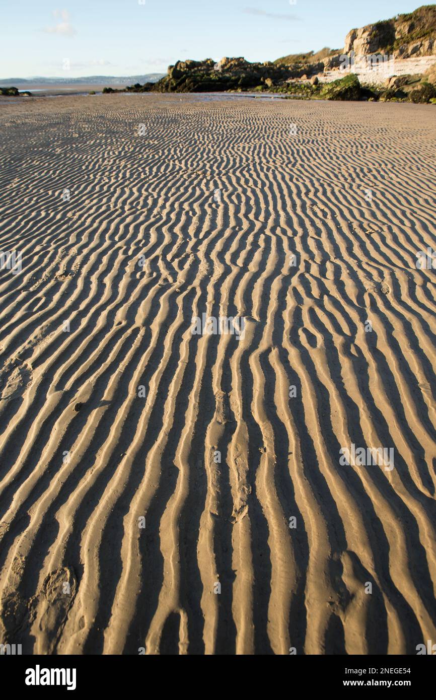 Le increspature sono rimaste nella sabbia a Jenny Brown’s Point vicino al villaggio di Silverdale con la bassa marea. Morecambe Bay è nota per i suoi tramonti, saline, cif Foto Stock