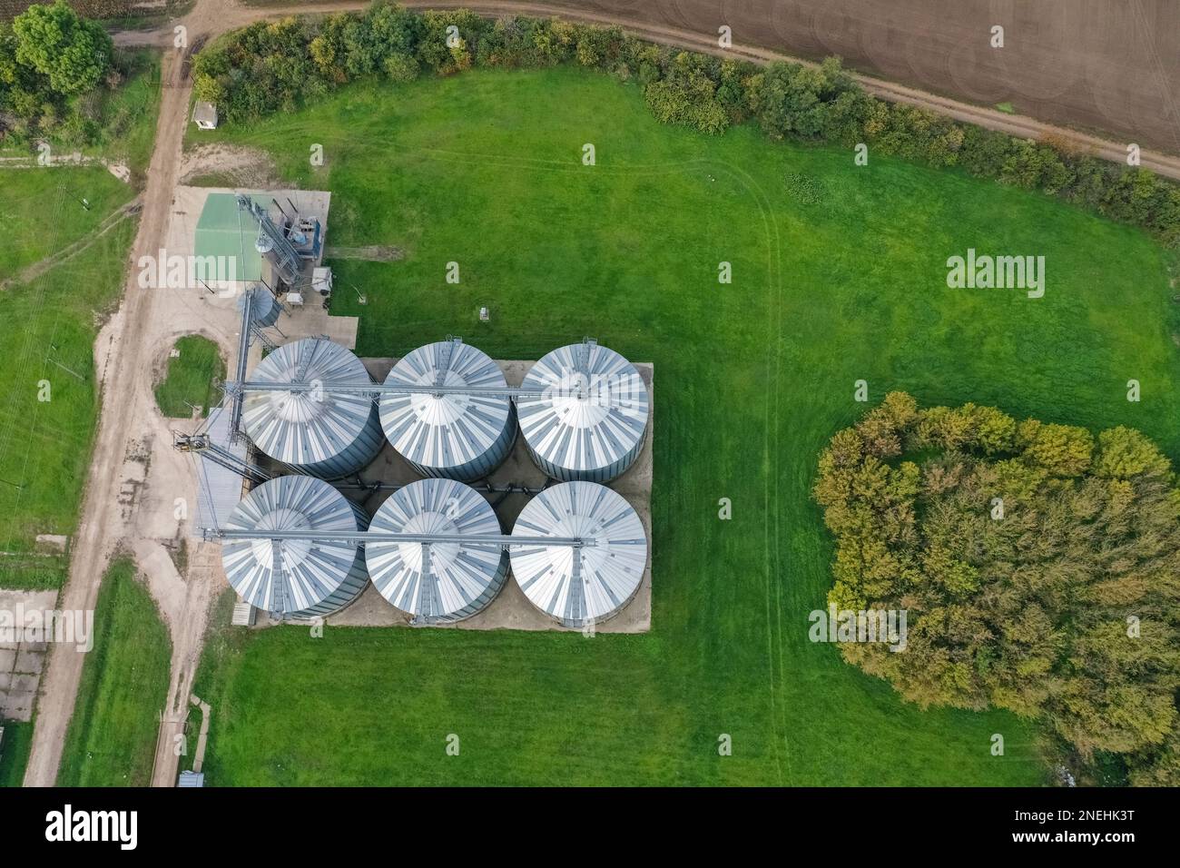 Silos agricoli sulla fattoria in autunno, vista ravvicinata drone. Granaio industriale, essiccatore elevatore, esterno dell'edificio, deposito ed essiccazione di grano, whe Foto Stock