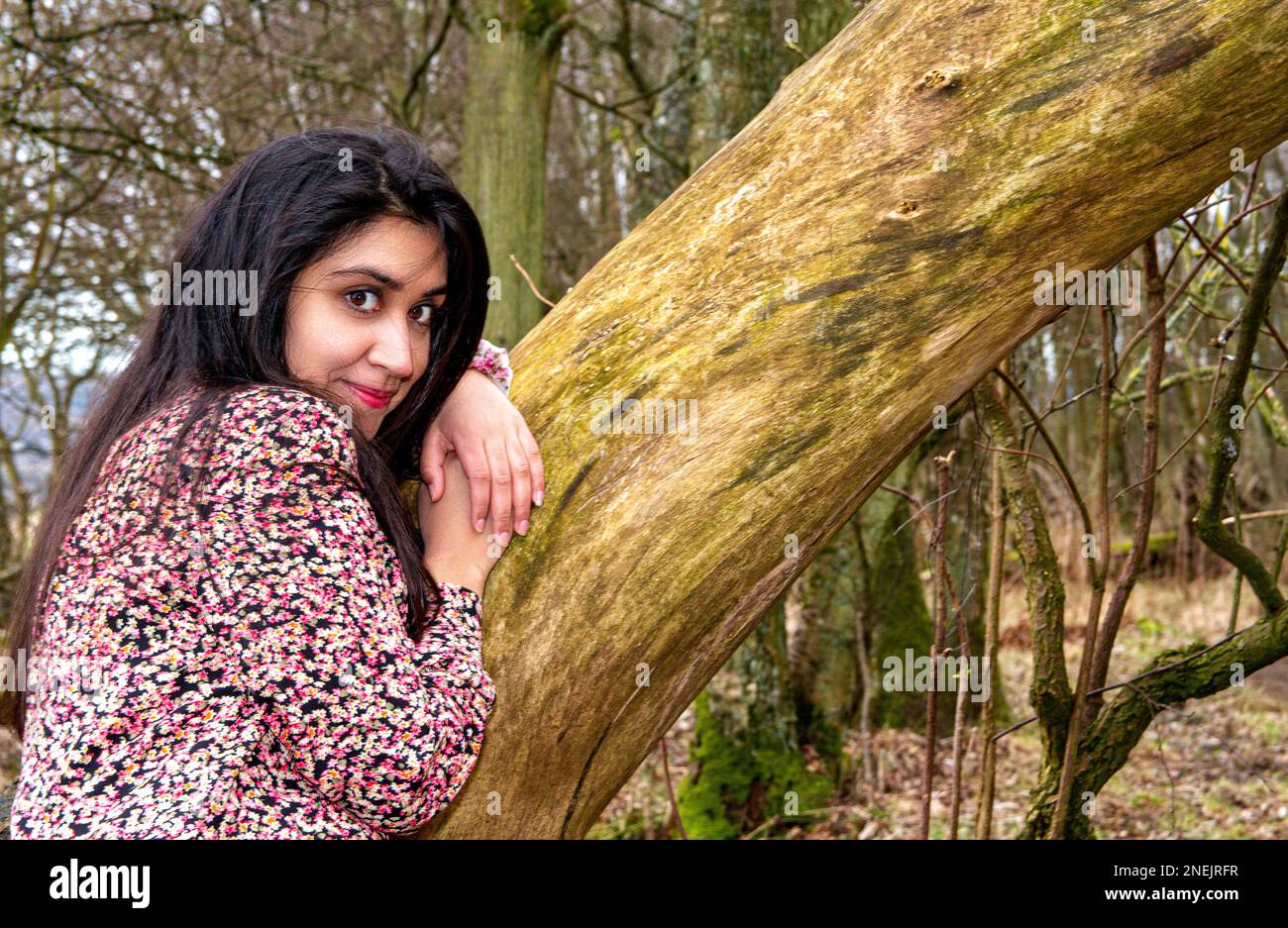 Una donna bella e alla moda trascorre la giornata facendo scattare la sua foto nei boschi del Clatto Country Park di Dundee in Scozia, Regno Unito Foto Stock