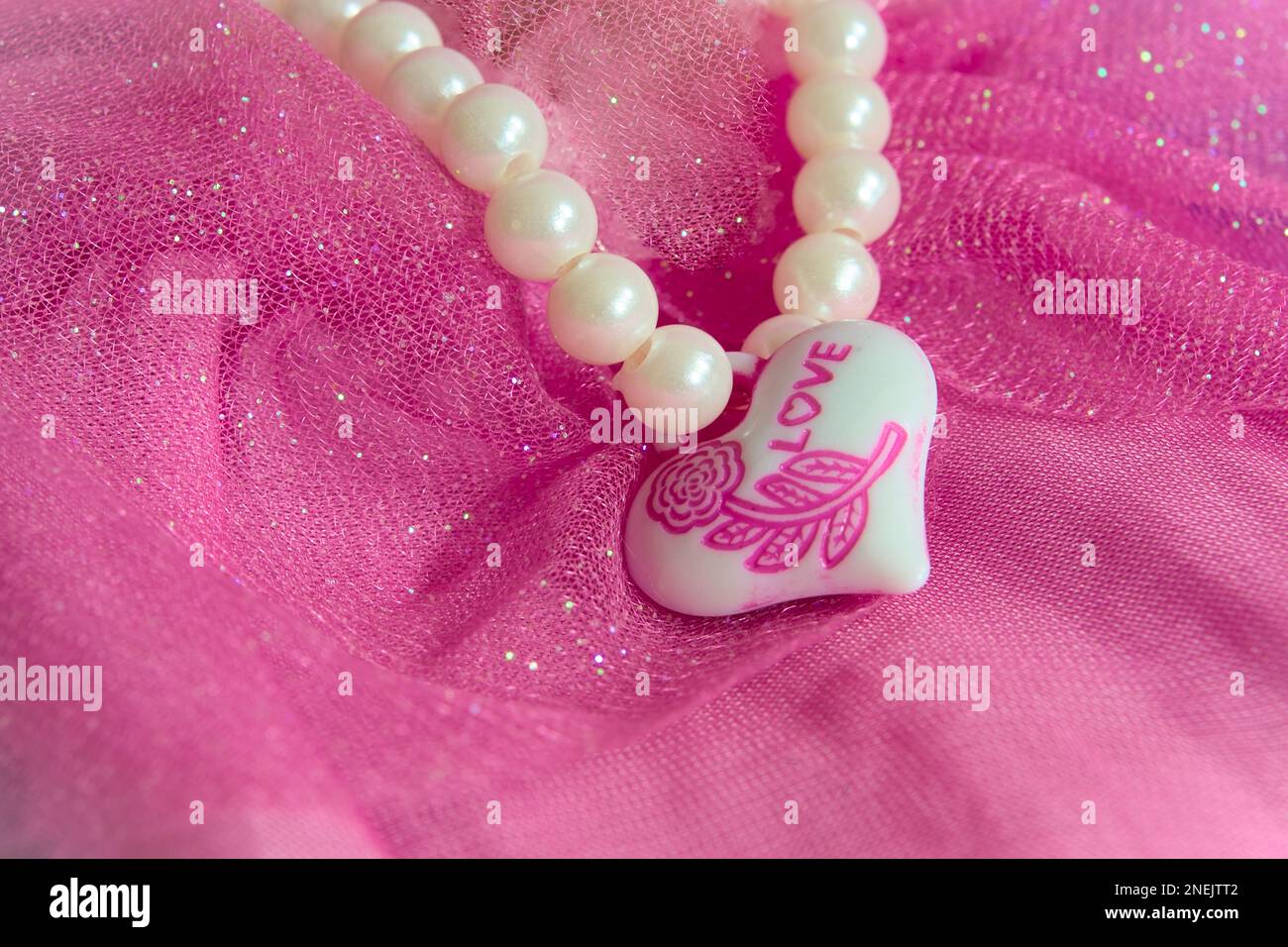 Una collana a forma di cuore rosa. Un dono che commette dal cuore con amore. Buon giorno di San Valentino. Foto Stock