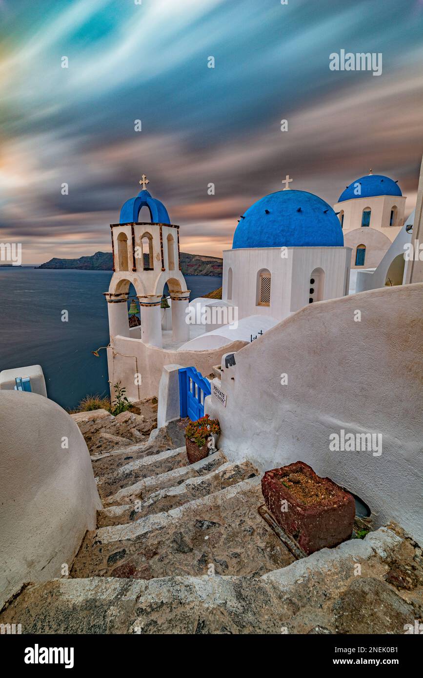 Vista sulla pittoresca chiesa con le tre cupole blu al crepuscolo, Santorini Foto Stock