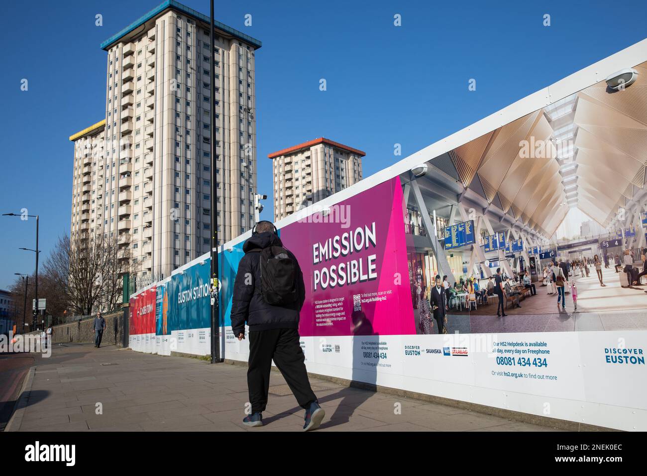 Londra, Regno Unito. 15th febbraio, 2023. Un membro del pubblico passa le esposizioni di marketing intorno al cantiere per la stazione di capolinea HS2 a Euston in direzione della tenuta di Ampthill Square. Il Cancelliere dello scacchiere Jeremy Hunt ha informato il 27 gennaio che il progetto ferroviario ad alta velocità raggiungerà Euston come originariamente previsto in seguito a notizie di giornali che affermano che la linea potrebbe terminare a Old Oak Common. Credit: Notizie dal vivo di Mark Kerrison/Alamy Foto Stock