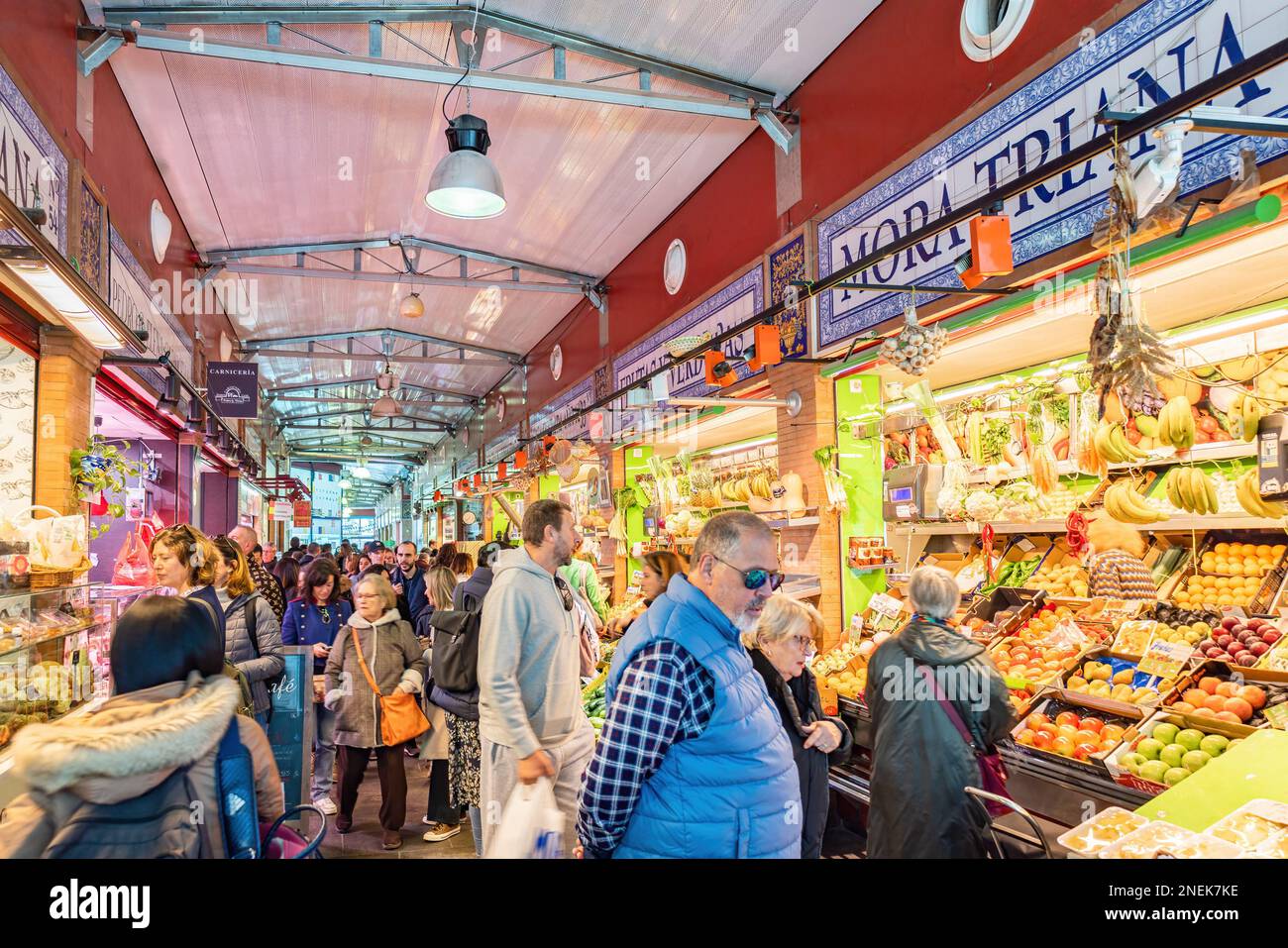 Siviglia, Spagna - 4 gennaio 2023: Interno del Mercado de Triana, un pittoresco mercato coperto con molte bancarelle che vendono prodotti agricoli, carne Foto Stock