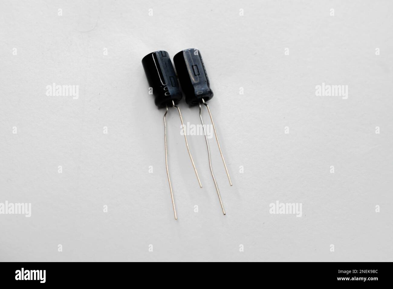 Condensatori multipli isolati su sfondo bianco. I condensatori sono utilizzati in diverse apparecchiature elettroniche come ventole, motori, ecc. Foto Stock
