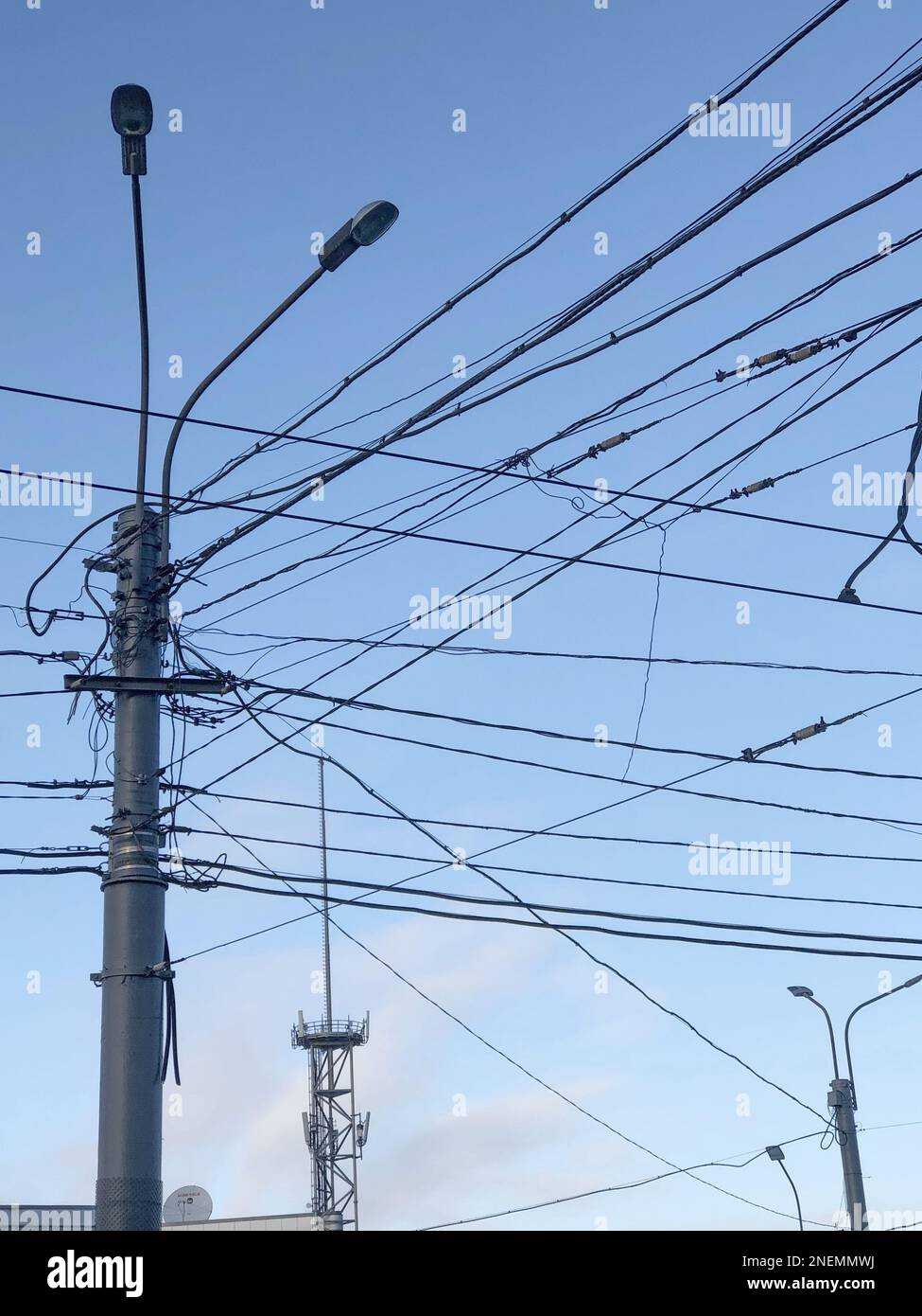 pole con molti fili elettrici nel cielo della città Foto Stock
