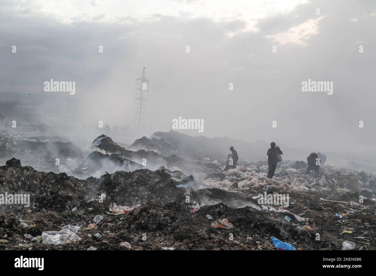 Nakuru, Kenya. 16th Feb, 2023. I raccoglitori di rifiuti raccolgono le cose in mezzo al fumo pesante dalla combustione di rifiuti, soprattutto plastica, tessuti, tra gli altri rifiuti presso il sito di scarico di Gioto. Un'indagine condotta dal gruppo ambientalista keniota senza scopo di lucro Clean-Up Kenya e Wild Light for the Changing Markets Foundation ha rilevato che i paesi europei scaricano ogni anno 37 milioni di capi di abbigliamento in plastica inutilizzabili in Kenya. L'indagine ha rilevato che più di un capo su tre di abbigliamento usato spedito in Kenya sono di qualità inferiore agli standard e immediatamente le vele vengono aperte diventano rifiuti. (Credit Image: © JaME Foto Stock