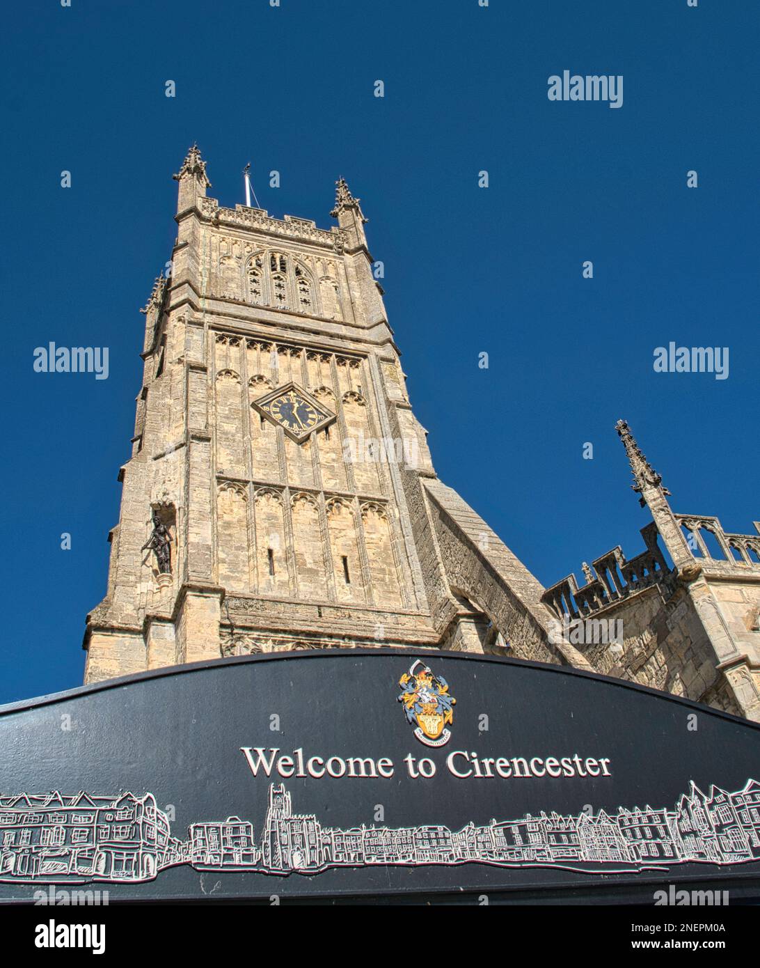 Cartello di benvenuto e la Torre della Chiesa Parrocchiale di San Giovanni Battista, Cirencester, Gloucestershire Foto Stock