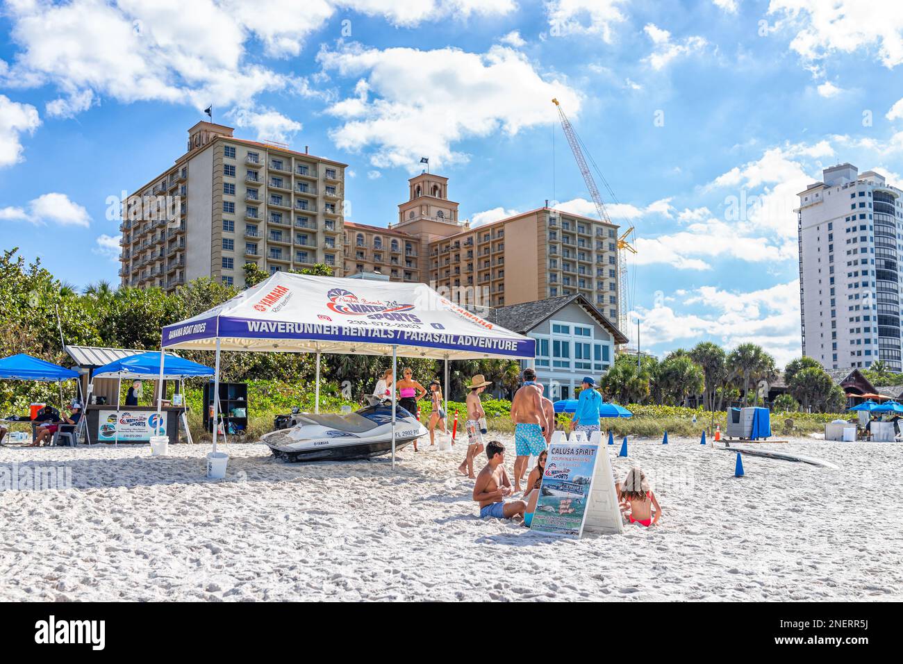 Napoli, USA - 28 dicembre 2021: Spiaggia di Vanderbilt in Florida a sud-ovest con l'hotel Ritz-Carlton e cartello per il noleggio di barche Waverunner e Banana Boat ri Foto Stock