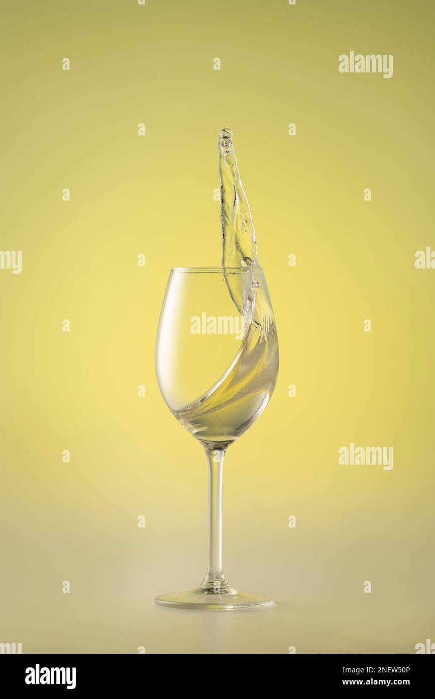 splash di vino bianco, vino bianco nel bicchiere, splash Foto Stock
